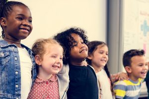 School children standing arm in arm smiling